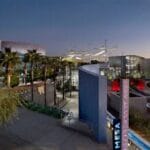 Night view of Mesa Arts Center exterior, featuring modern architecture, palm trees, and illuminated signage.