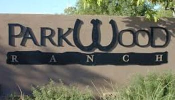 Sign displaying the words "Parkwood Ranch" with decorative text, surrounded by greenery.